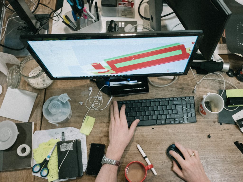 person using computer on brown wooden table